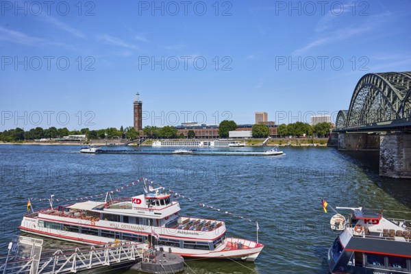 Rhine river, Hohenzollernbrücke pedestrian and railway bridge, excursion ship Willi Ostermann, Cologne-Düsseldorfer Deutsche Rheinschiffahrt GmbH, gangway, wharf, general architecture, high-rise buildings, exhibition tower, paddock, blue sky, cirrus clouds, Trankgassenwerft, Cologne, district-free city, North Rhine-Westphalia, Germany