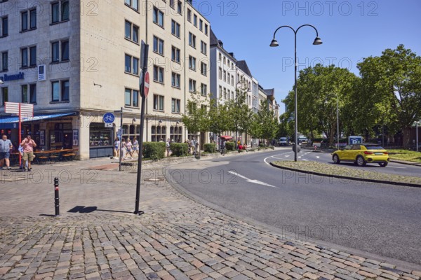 Residential and commercial buildings, general architecture, houses, residential buildings, pedestrian zone, barrier bollard, alleyway, curve, cobblestone walkway, lantern, car, meadow, trees, blue sky, cloudless, confluence Heumarkt in Markmannsgasse, Cologne, district-free city, North Rhine-Westphalia, Germany