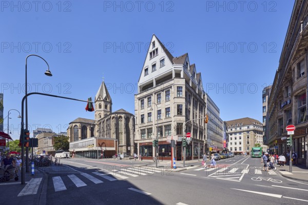 Corner building, general architecture, residential buildings and commercial buildings, St. Andreas Dominikanerkirche church, roads, pedestrian crossing, pedestrian as accessories, blue sky, cloudless, intersection of Komödienstraße, Marzellenstraße with Cardinal-Höffner-Platz, Cologne, district-free city, North Rhine-Westphalia, Germany