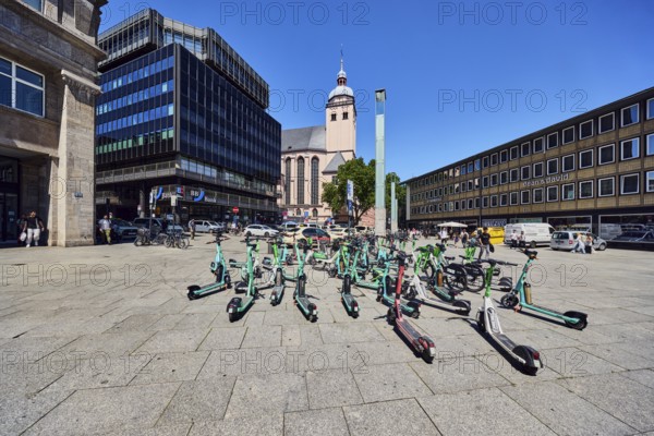 Traffic problem parked e-scooters in the city, general architecture, commercial building, modern building, church of St. Mary's Ascension, vehicles, BBBank eG, blue sky, cloudless, station forecourt, Cologne, district-free city, North Rhine-Westphalia, Germany