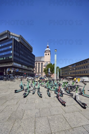 Traffic problem parked e-scooters in the city, general architecture, commercial building, modern building, church of St. Mary's Ascension, vehicles, BBBank eG, blue sky, cloudless, station forecourt, Cologne, district-free city, North Rhine-Westphalia, Germany