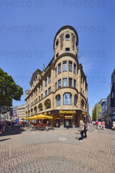 Historic commercial building Palatium, architect Wilhelm Kreis, sandstone building material, Merzenich bakery, corner building, shops, shopping, pedestrian zone, trees, pedestrians as accessories, blue sky, cloudless, intersection Hohe Straße with Gürzenichstraße, Cologne, district-free city, North Rhine-Westphalia, Germany