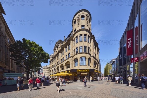Historic commercial building Palatium, architect Wilhelm Kreis, sandstone building material, Merzenich bakery, corner building, shops, shopping, pedestrian zone, trees, pedestrians as accessories, blue sky, cloudless, intersection Hohe Straße with Gürzenichstraße, Cologne, district-free city, North Rhine-Westphalia, Germany