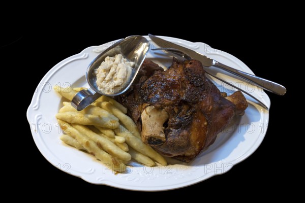 Pork knuckle, French fries and horseradish served on a plate, Ukraine