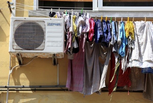 The laundry hangs to dry on a line in front of the window, next to it an air conditioner, typical scene from the small town of Mesola in the Po Delta, Emilia-Romagna, Italy/The laundry hangs to dry on a line in front of the window, next to it an air conditioner, typical scene from the small town of Mesola in the Po Delta, province of Ferrara, Italy