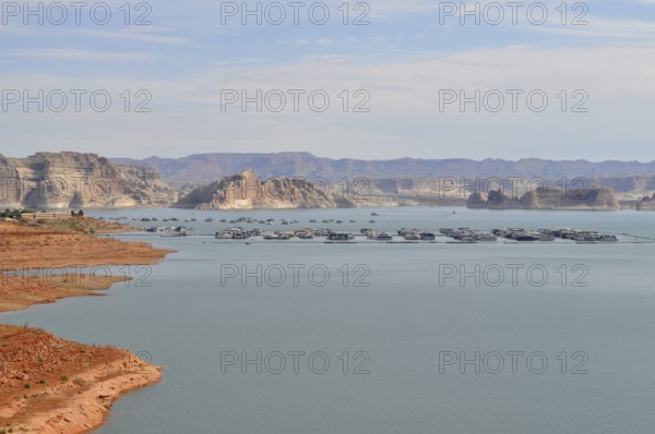 Peaceful water area of Lake Powell with floating houseboats and mountain scenery, Arizona, USA