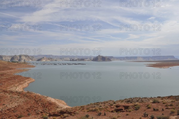 Large, quiet lake surrounded by dry, sandy landscape and hills, Lake Powell, Arizona, USA