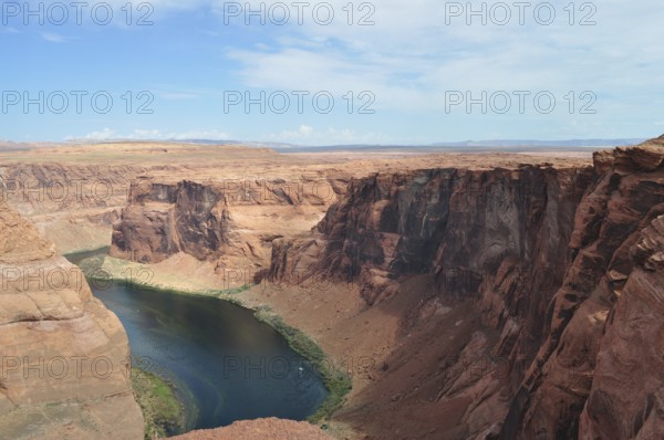 Red rock edges and a flowing river in the middle of the vast desert landscape, Horseshoe Bend, Colorado River, Arizona, USA
