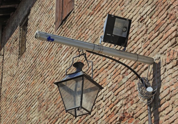 Historic lantern and modern halogen spotlight in La Rocca, Novellara Castle, Emilia-Romagna, Italy