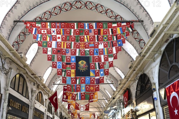 Istanbul, Turkey. June 23rd 2025. A display of flags of the world surrounding an Ottoman flag hanging from the ornate ceiling inside the Grand Bazaar, Istanbul, Turkey