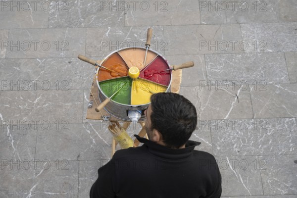 Istanbul, Turkey. December 2nd 2025. A Turkish street vendor selling brightly colored Macum, a popular soft, sweet, and colorful Turkish toffee paste. Istanbul Turkey