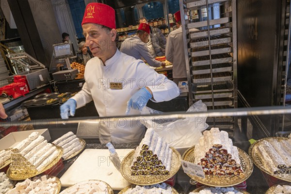 Istanbul, Turkey. December 2nd 2025. Turkish fez wearing staff inside Hafiz Mustafa baklava sweet shop along Istiklal Street, Istanbul, Turkey
