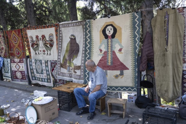 Tbilisi, Georgia. July 11th 2025. Street stall vendor at the Dry Bridge Flea Market selling antiques and old Soviet memorabilia in Tbilisi Old Town near the River Kura
