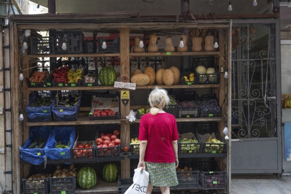 Tbilisi, Georgia. July 29th 2025. A woman shopping at a local grocery shop selling fruit and vegetables in the Old Town of Tbilisi, Georgia