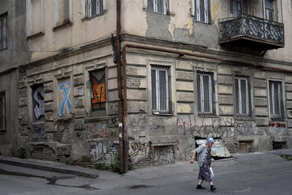 Tbilisi, Georgia. July 15th 2025. An elderly Georgian lady crossing the street in the downtown neighborhood of Old Tbilisi, Georgia