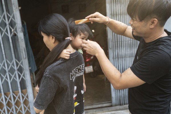 Bangkok, Thailand. March 18th 2025. A local family outside their shop house in the streets of Talat Noi, Bangkok, Thailand, Asia