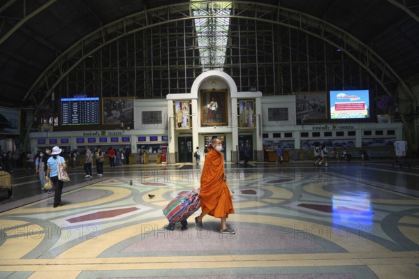 Bangkok, Thailand. February 16th 2025. A Buddhist monk with his luggage in the waiting room of Hua Lamphong Railway Station, Bangkok, Thailand