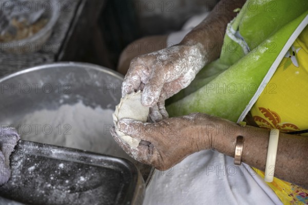 A Thai women preparing traditional pastry to be baked and sold in a Bangkok street market, Thailand