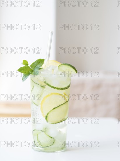 Cucumber detox water with lemon, mint, ice, and a straw offering a healthy refreshment