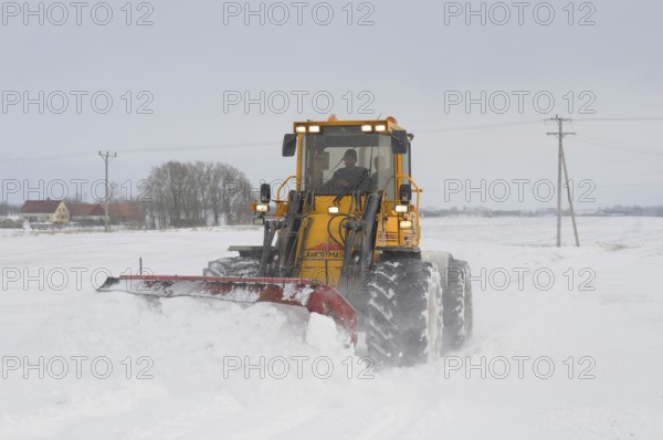 Loader clearing snow on road in Skurup municipality, Skåne county, Sweden, Scandinavia