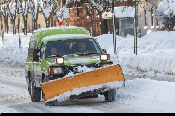 Small truck with mounted snow plow clearing snow on streets in Ystad, Skåne County, Sweden, Scandinavia
