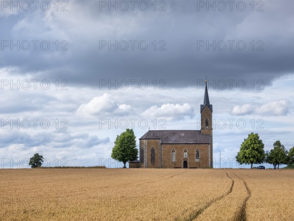 View over a wheat field to the Bischwinder chapel Maria Hilfe der Christenheit, Bischwind, Lower Franconia, Bavaria, Germany