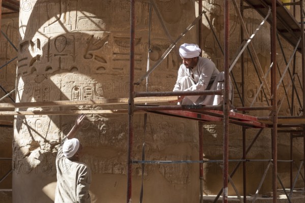 Luxor, Egypt. December 12th 2022 Local Egyptian workers cleaning and restoring the ancient columns of Karnak Temple near the River Nile, Luxor, Upper Egypt