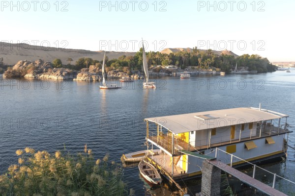 Aswan, Egypt. December 9th 2022 Beautiful scenic view of an Egyptian house boat on the River Nile from Elephantine Island, Aswan, Egypt