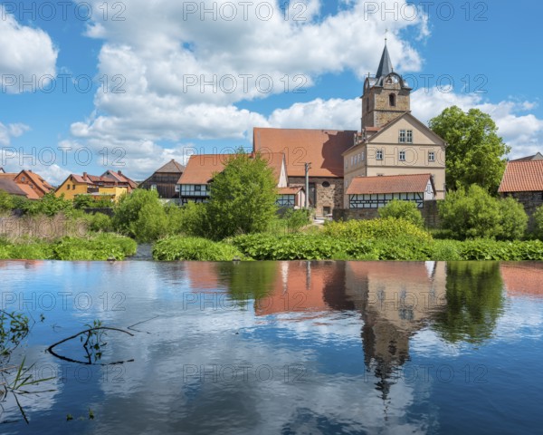 View across the Werra river to the small village of Themar with church and half-timbered houses, Themar, Thuringia, Germany