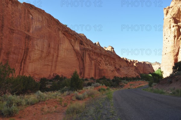 A narrow road snakes through impressive red rock walls in a dry desert landscape, Grand Staircase Escalante National Monument, Utah, USA