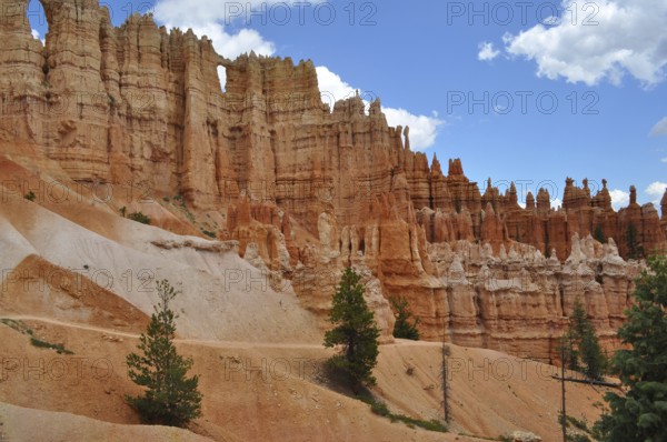 Hiking trail leads past bizarre red rock needles and pine trees in Bryce Canyon National Park, Utah, USA
