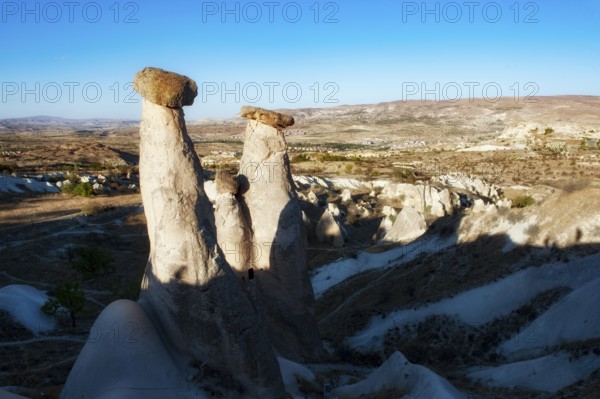 Soft morning light on the fairy chimney rock formations known as the Three Graces, part of the dramatic Anatolian landscape of Cappadocia in central, Turkey