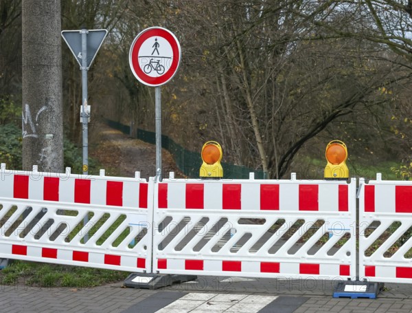 Castrop-Rauxel, North Rhine-Westphalia, Germany - A bicycle path, footpath is blocked off by signs, barrier fence, warning beacons, here due to a probe of war