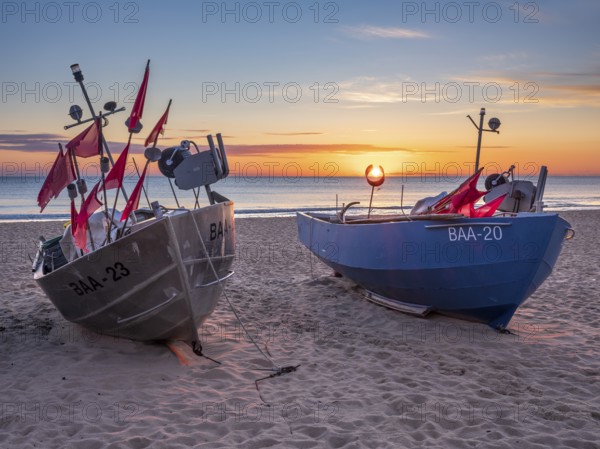 Fishing boats with red flags on fishing beach on the Baltic Sea at sunrise, Baabe, Mönchgut peninsula, Rügen island, Mecklenburg-Western Pomerania, Germany