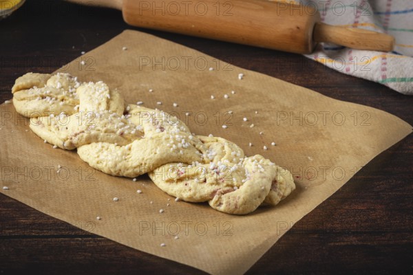Braided yeast braid with sugar on baking paper