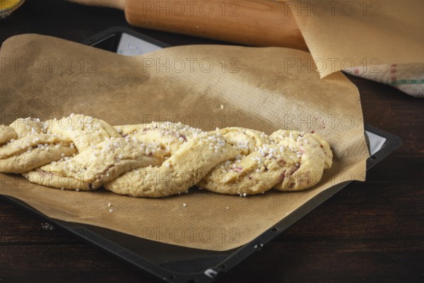 Fresh yeast braid with baking paper on a tray