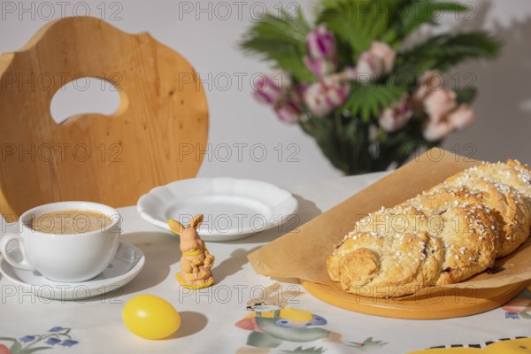 Breakfast table with coffee, yeast braid and decoration for Easter