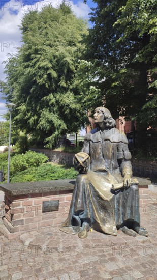 Bronze statue of Nicolaus Copernicus on a stone bench in Olsztyn, Masuria, Poland
