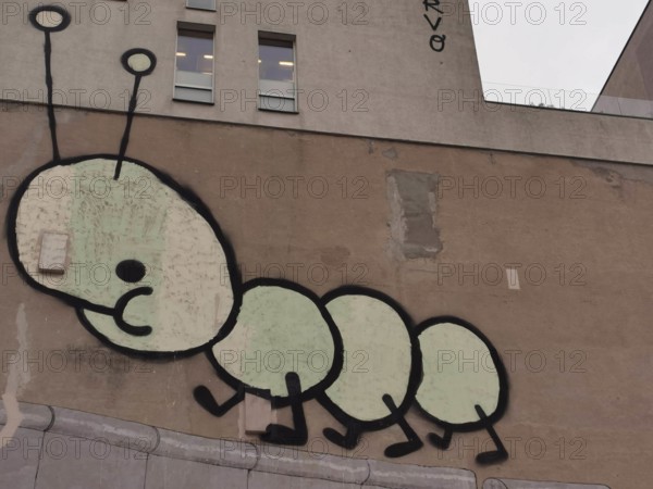 Creative wall graffiti in the form of a cartoon caterpillar on a building, Berlin