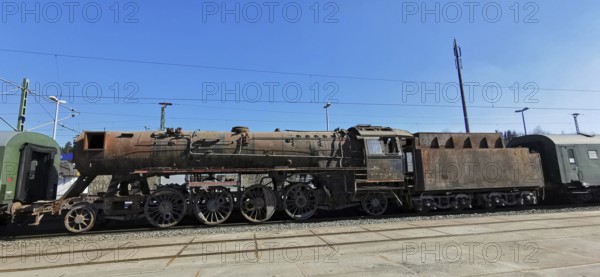 Transfer of a rusted historic steam locomotive on rails under clear blue skies at the train station, Rennsteig, Frankenwald nature park Park