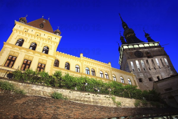 Romania, hour tower and the cultural house at the blue hour in the historic old town of Sighisoara, German Sighisoara, town in the Mures district in Transylvania, UNESCO World Heritage Site
