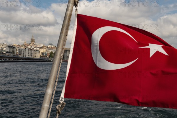 Istanbul, Turkey. September 21st 2021 Turkish flag flying from the rear of a Bosporus ferry with the Galata Tower and European side of Istanbul in the background, Turkey