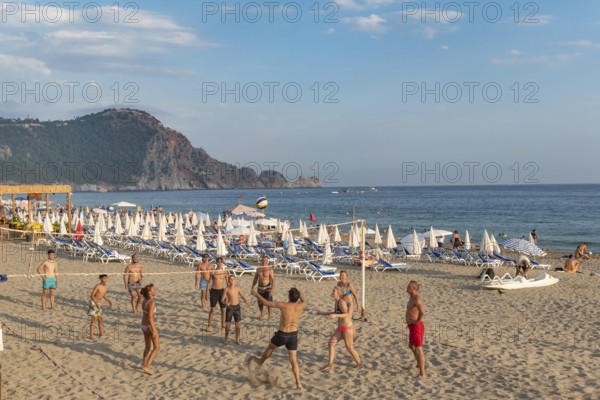 Holiday makers playing volleyball on Cleopatra Beach in the Turkish holiday resort town of Alanya on the Mediterranean coast of Turkey, the Turkish Riviera