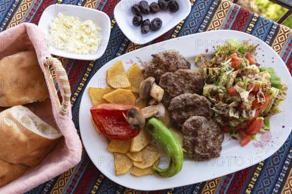 Typical Turkish meal of Kofte with green pepper, mushroom, salad and French fries