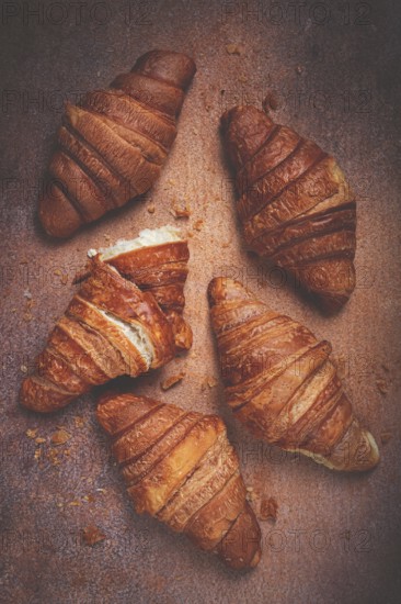 Fresh croissants, breakfast, top view, on the table, brown background, no people