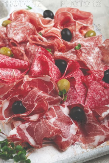 Assorted, meat appetizer, prosciutto, salami and ham, with olives, close-up, breakfast, top view, close-up, without people