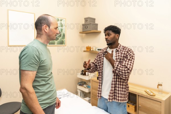 Two men in a counseling session engage in serious, supportive conversation in a clinical office, exchanging guidance, empathy and problem solving for mental health and wellness
