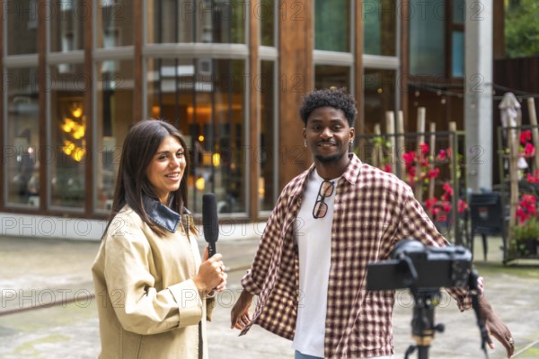 Journalist holding a microphone interviewing a young man on a city street, documenting the conversation with a camera on a tripod for a live broadcast or social media content