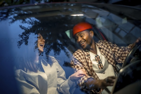 Happy interracial couple sharing a laugh while driving, reflecting joy and freedom on their journey, depicting love and connection in a casual setting