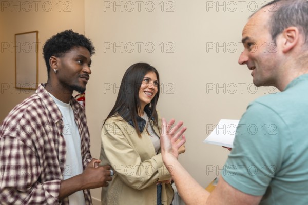 Diverse indoor group smiling, talking and listening during a casual meeting or workshop, exchanging ideas and building collaboration, networking and friendly teamwork